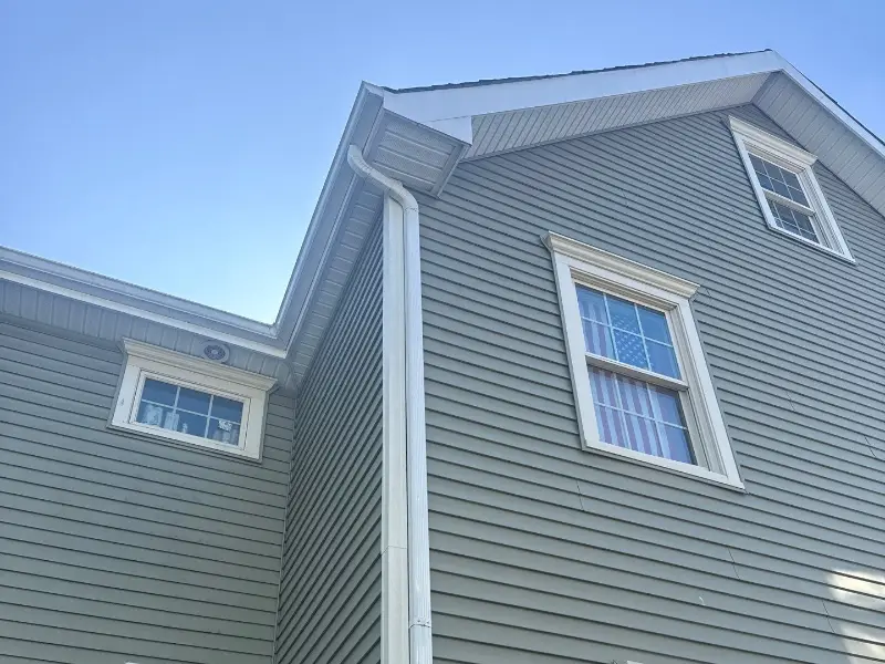 Gray lap siding and white trim on a two-story home in Westfield NJ, installed by Herts Roofing & Construction
